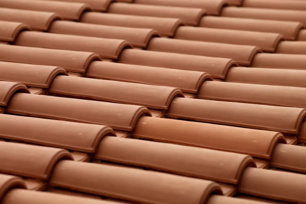 Vista detalhada de telhas cerâmicas em tons de terracota, ideal para revestimento de telhados, destacando a qualidade e durabilidade desse material.