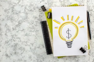 Imagem de uma lâmpada com símbolo de dólar, representando a validação de ideias para investimentos, com materiais de escritório ao redor, ideal para aprender como validar uma ideia antes de investir dinheiro.
